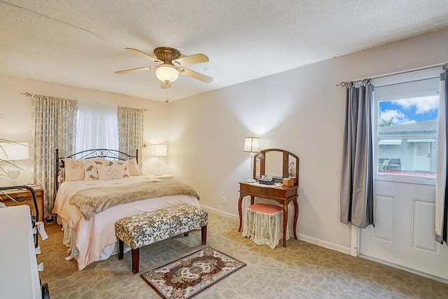 bedroom featuring ceiling fan, a textured ceiling, and carpet