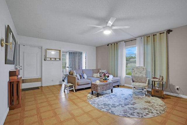 living room with a textured ceiling and ceiling fan