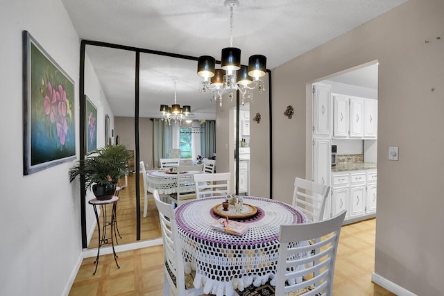 dining space with a textured ceiling and a chandelier