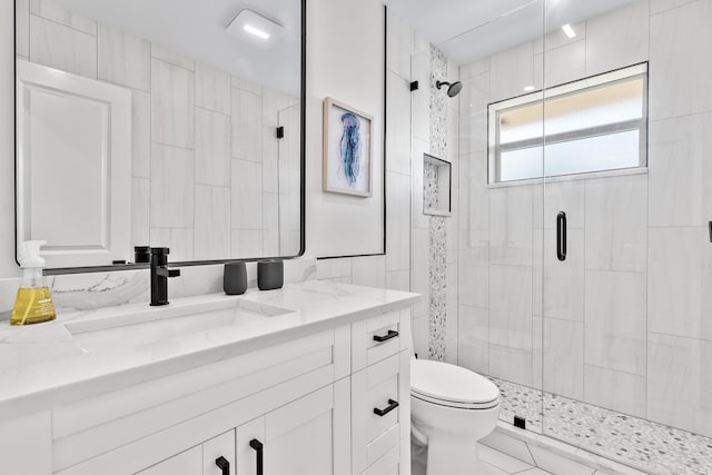 bathroom featuring vanity, toilet, and walk in shower