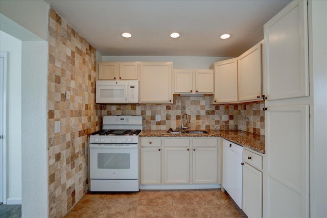 kitchen featuring white cabinetry, white appliances, sink, and dark stone countertops