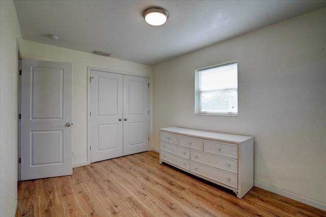 unfurnished bedroom featuring a closet and light hardwood / wood-style flooring