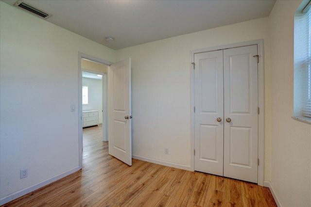 unfurnished bedroom with a closet and light wood-type flooring