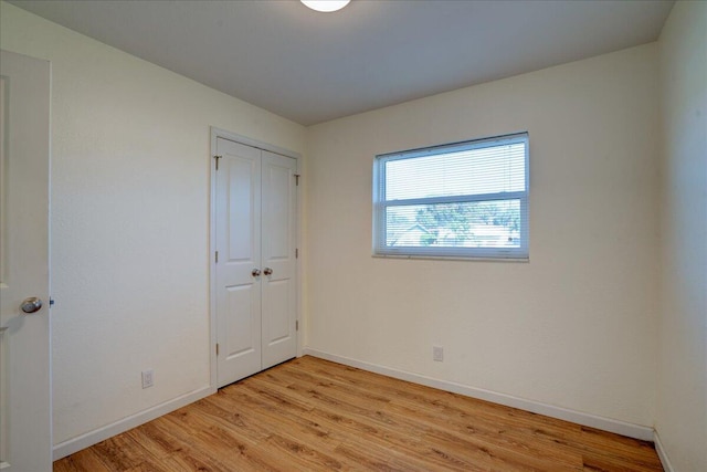 unfurnished bedroom featuring a closet and light wood-type flooring