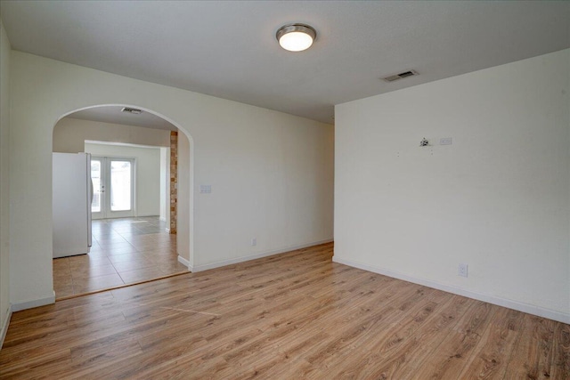 empty room featuring light hardwood / wood-style floors and french doors