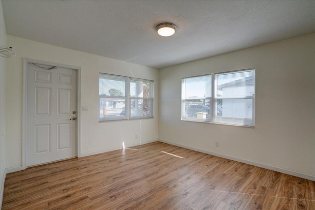 interior space with a textured ceiling and light wood-type flooring