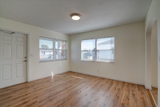 foyer entrance with light hardwood / wood-style floors and a textured ceiling