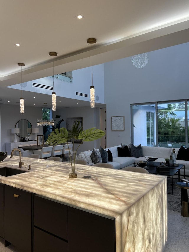 kitchen featuring open floor plan, a sink, and pendant lighting