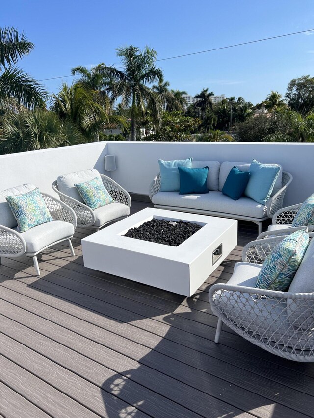 wooden terrace featuring an outdoor living space with a fire pit