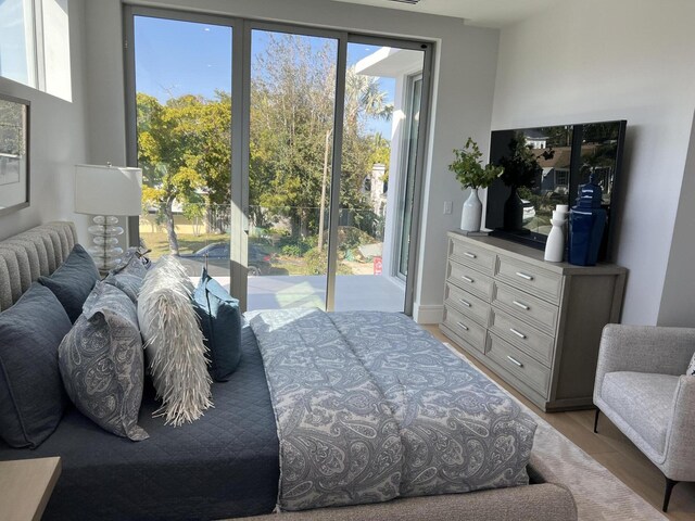 bedroom with access to exterior and light wood-style flooring