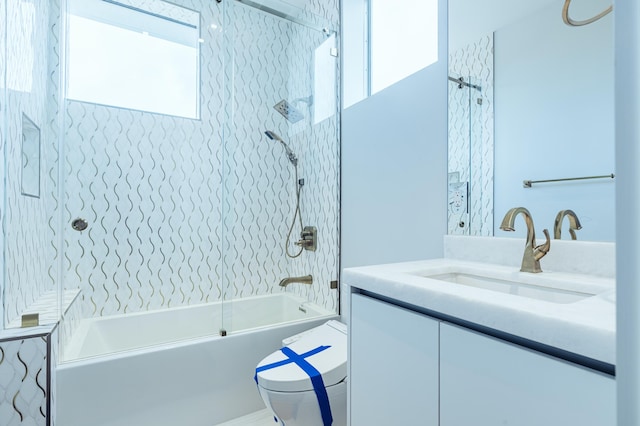 full bathroom with vanity, tiled shower / bath combo, and toilet