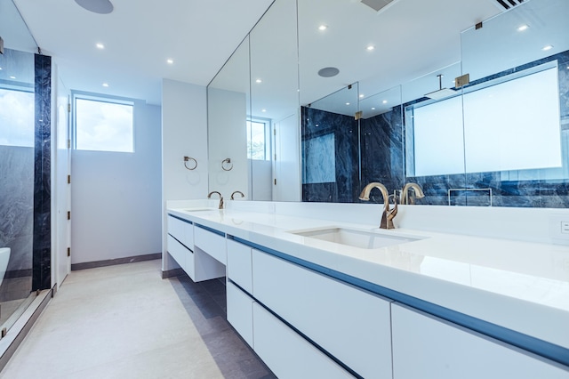 bathroom with vanity, a healthy amount of sunlight, and walk in shower