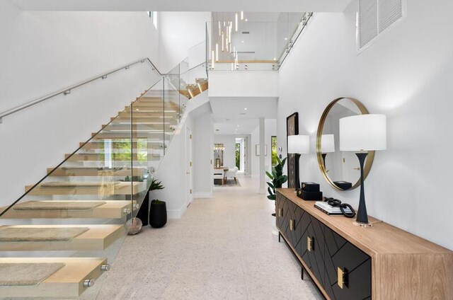260 31st St, West Palm Beach, FL 33407 - entrance foyer with stairs, dark speckled floor, a towering ceiling, and baseboards