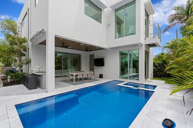 260 31st St, West Palm Beach, FL 33407 - rear view of house featuring a balcony, stucco siding, a patio, a pool with connected hot tub, and a ceiling fan