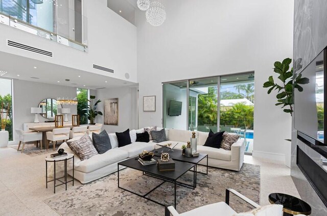 260 31st St, West Palm Beach, FL 33407 - living room featuring a high ceiling, healthy amount of natural light, and baseboards