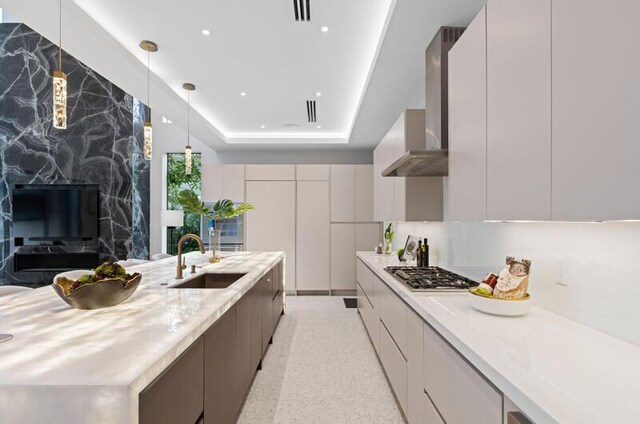 260 31st St, West Palm Beach, FL 33407 - kitchen featuring modern cabinets, a sink, stainless steel gas cooktop, wall chimney exhaust hood, and light countertops