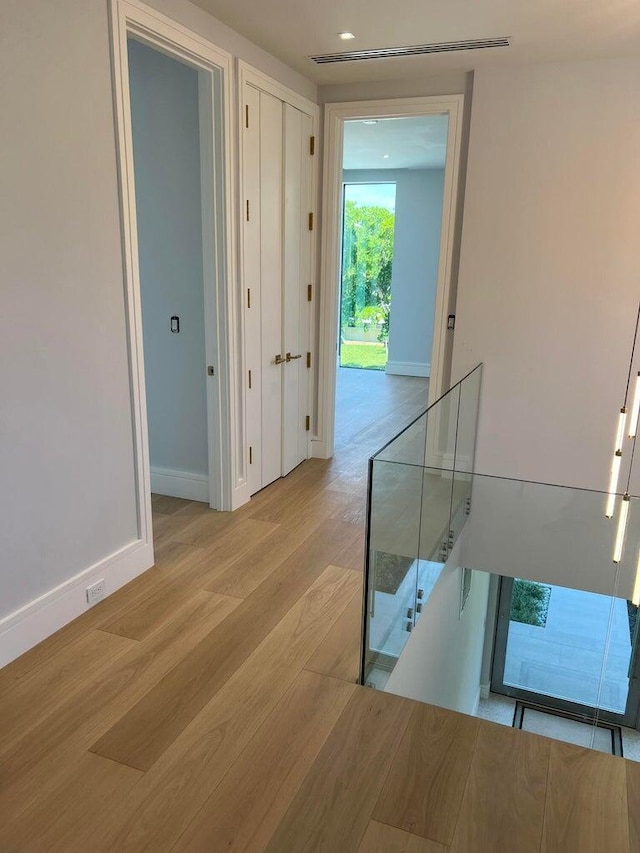 corridor featuring recessed lighting, wood finished floors, visible vents, and baseboards