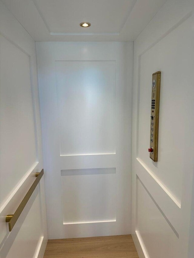 details with recessed lighting, elevator, and wood finished floors