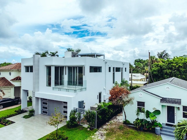 view of front of property featuring a garage, concrete driveway, and stucco siding