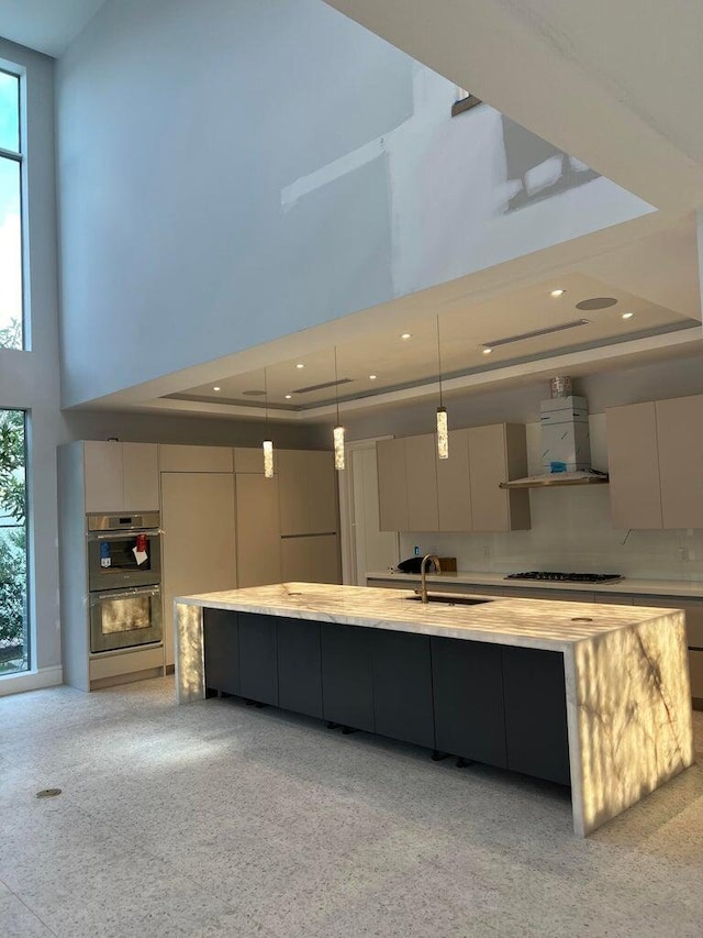 kitchen featuring cooktop, extractor fan, modern cabinets, and a raised ceiling