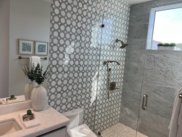 bathroom featuring a tile shower, vanity, and toilet