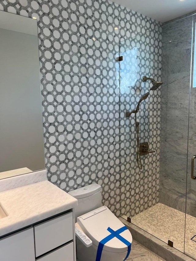 bathroom with toilet, a stall shower, and vanity