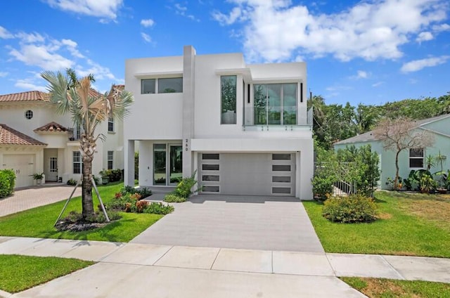 260 31st St, West Palm Beach, FL 33407 - modern home with stucco siding, driveway, a front lawn, and a garage