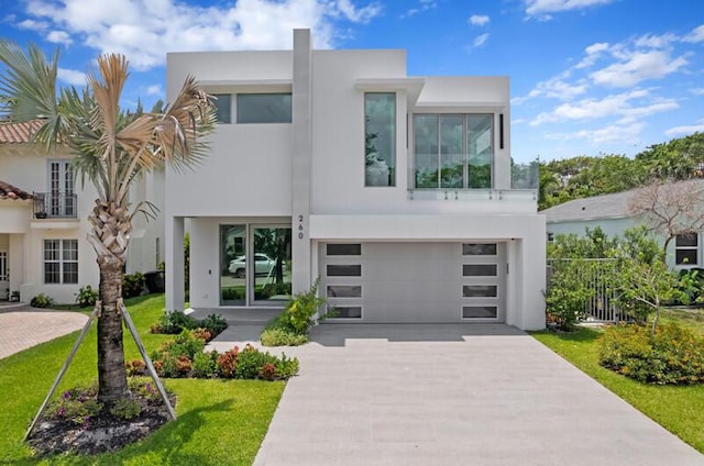 260 31st St, West Palm Beach, FL 33407 - modern home featuring stucco siding, driveway, an attached garage, and french doors