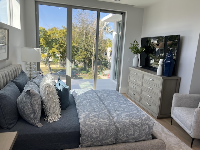 bedroom with access to outside and light wood-style flooring