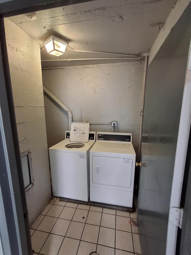 laundry room with light tile patterned floors and washer and clothes dryer