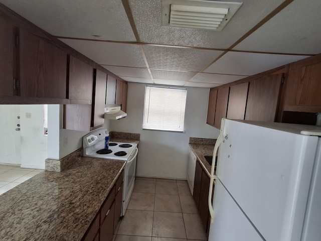 kitchen with white appliances, a paneled ceiling, and light tile patterned flooring