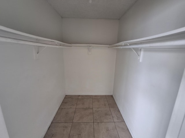 walk in closet with light tile patterned floors