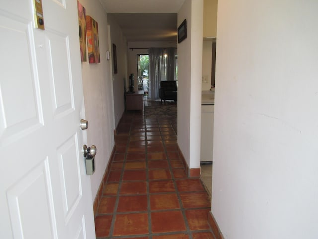 hall featuring dark tile patterned floors