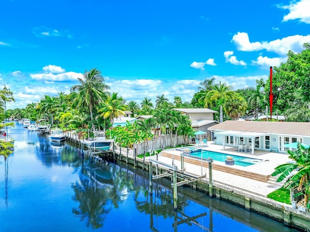 view of pool with a water view, a patio area, and a dock