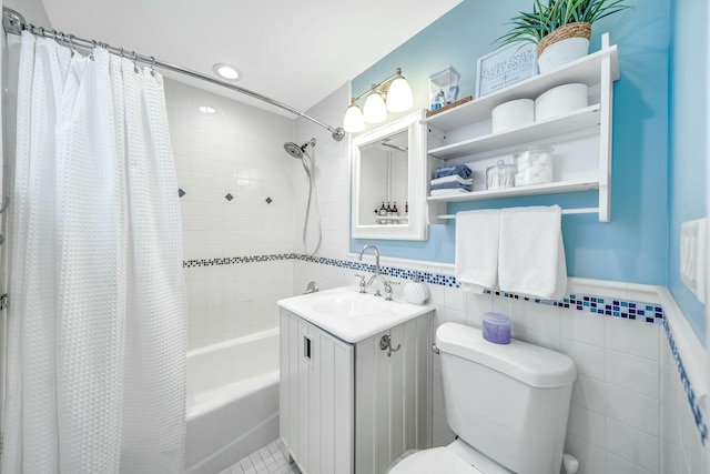 full bathroom with vanity, toilet, tile walls, and shower / tub combo with curtain