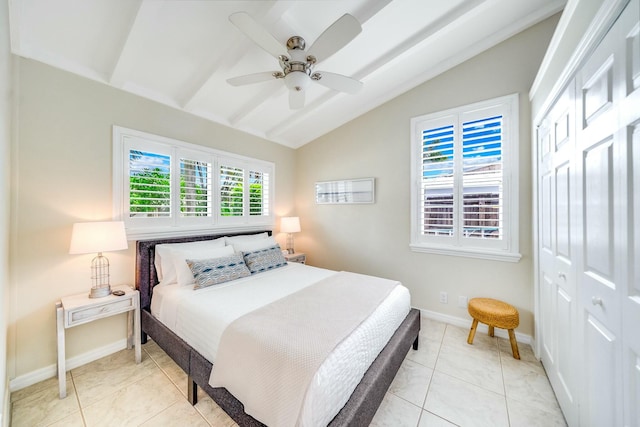 bedroom with ceiling fan, light tile patterned floors, a closet, and vaulted ceiling