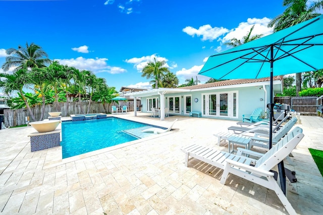 view of pool with an in ground hot tub, a patio, and french doors