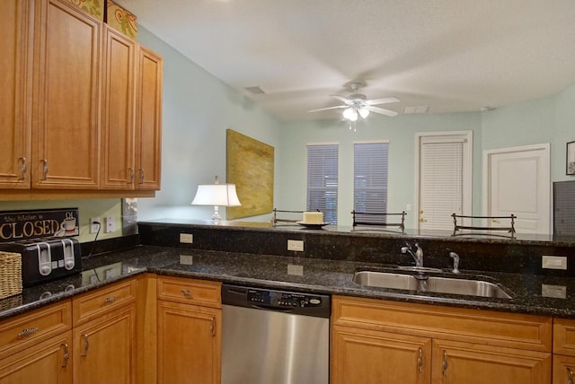 kitchen with ceiling fan, sink, dishwasher, and dark stone countertops