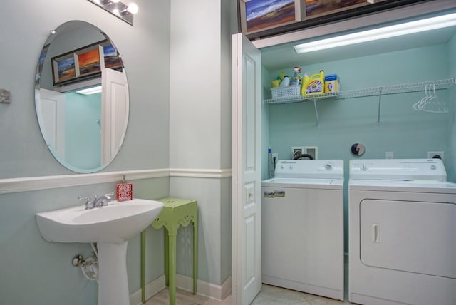 bathroom featuring sink, washer and clothes dryer, and tile patterned flooring