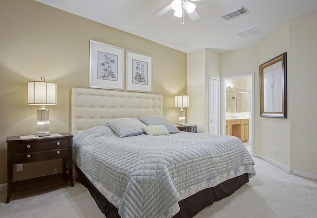 bedroom featuring ceiling fan, light colored carpet, and connected bathroom