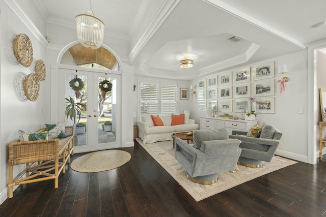 living area with french doors, ornamental molding, dark hardwood / wood-style floors, and an inviting chandelier