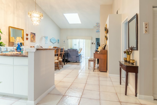 interior space with vaulted ceiling with skylight and light tile patterned floors