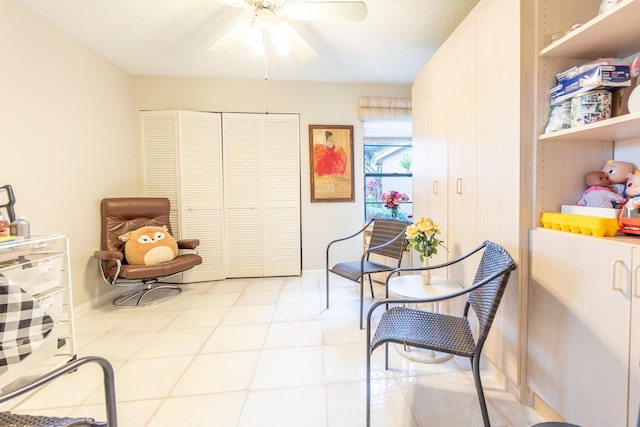 sitting room with ceiling fan and light tile patterned flooring