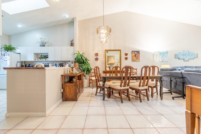 dining room featuring vaulted ceiling with skylight, light tile patterned floors, and a notable chandelier