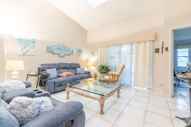 living room with a skylight, high vaulted ceiling, and light tile patterned floors