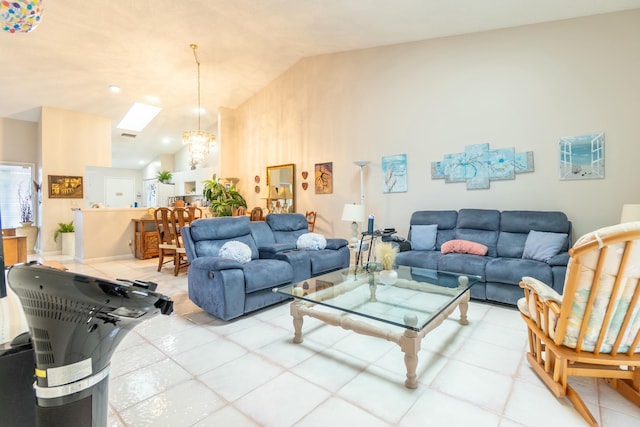 living room with vaulted ceiling with skylight, light tile patterned floors, and an inviting chandelier