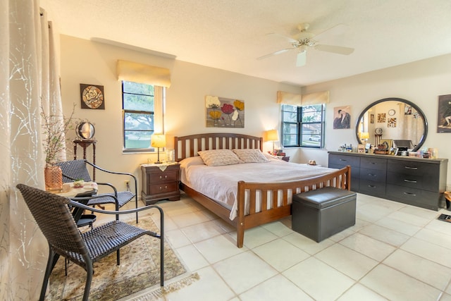 tiled bedroom with multiple windows, a textured ceiling, and ceiling fan