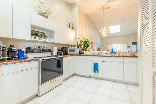 kitchen featuring vaulted ceiling, hanging light fixtures, white cabinetry, tasteful backsplash, and white appliances