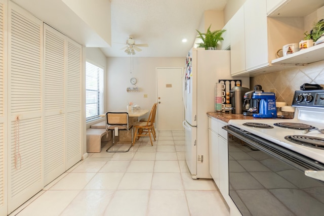 kitchen featuring ceiling fan, backsplash, electric range, and white cabinets