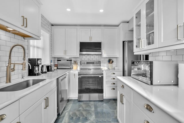 kitchen featuring white cabinetry, appliances with stainless steel finishes, sink, and decorative backsplash